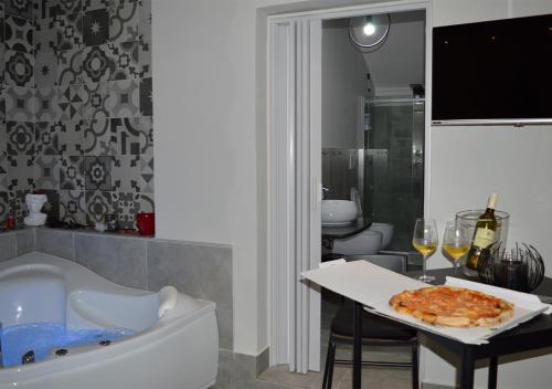 a bathroom with a tub and a pizza on a table at B&B Aquino in Terrazza in Aquino