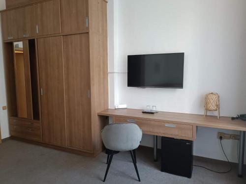 Habitación con escritorio, TV y silla. en Rezidence Dlouha 17 en Praga