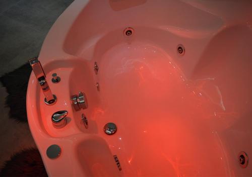 a pink bathtub with a red liquid in it at B&B Aquino in Terrazza in Aquino