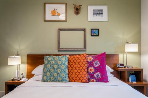 sypialnia z łóżkiem z kolorowymi poduszkami w obiekcie Kasa El Paseo Miami Beach w Miami Beach