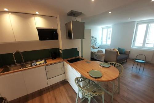 une cuisine et un salon avec une table et des chaises dans l'établissement Classé 3 Etoiles IDEAL VIENNE Centre ville 20 min de LYON, à Vienne