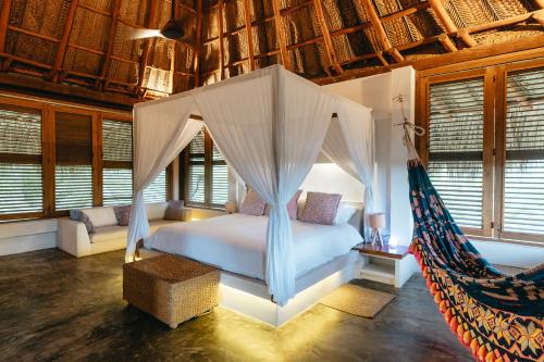 a bedroom with a bed and a hammock at Casa Origen in Los Naranjos