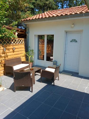 un patio con 2 mesas y sillas y una puerta en 2 chambres d'hôtes au calme proche centre ville, en Mont-de-Marsan