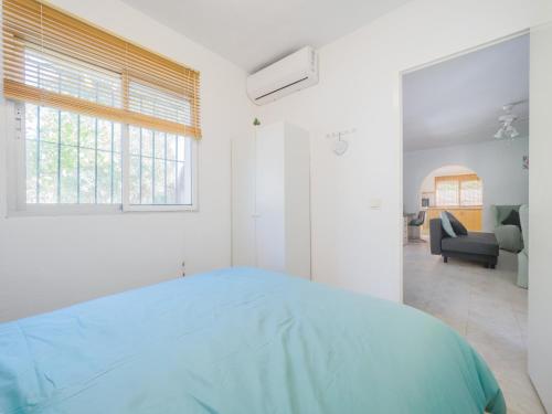 ein weißes Schlafzimmer mit einem Bett und ein Wohnzimmer in der Unterkunft Cubo's Cortijo La Bolina in Cártama