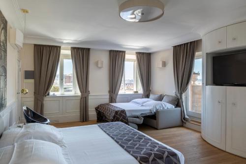 a hotel room with two beds and a flat screen tv at Hotel Scalinata Di Spagna in Rome