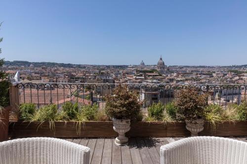 a balcony with two chairs and a view of a city at Hotel Scalinata Di Spagna in Rome