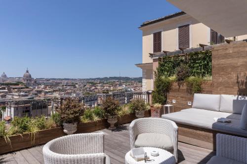 a patio with a couch and chairs on a balcony at Hotel Scalinata Di Spagna in Rome
