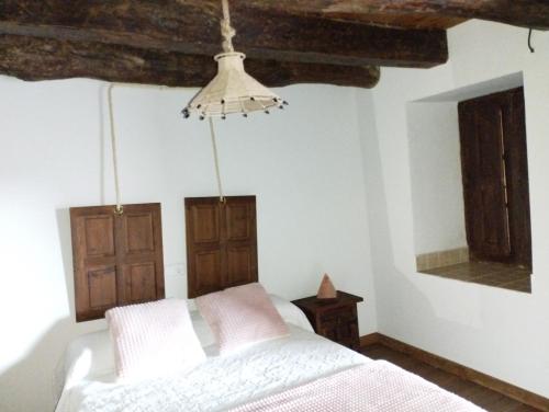a bedroom with a white bed and wooden ceilings at CASA RURAL VEGASAN in Santa Colomba de la Vega