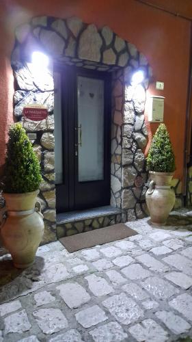 una porta d'ingresso di un edificio con due piante in vaso di La Tavernetta a Pignola