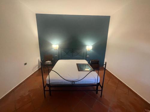 Bett in einem Zimmer mit zwei Lichtern an der Wand in der Unterkunft Sant'onofrio suite 2.0 in Trabia