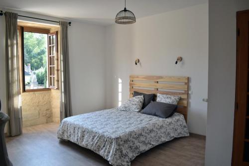 een slaapkamer met een bed en een raam bij Chambre d'hôtes Auriac du Périgord in Auriac-du-Périgord