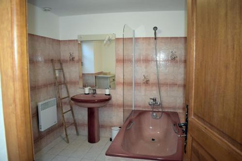 een badkamer met een koperen bad en een wastafel bij Chambre d'hôtes Auriac du Périgord in Auriac-du-Périgord