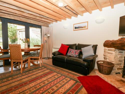 a living room with a leather couch and a table at Tinkley Cottage in Nymphsfield