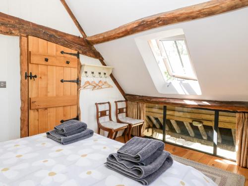 a room with a bed with towels on it at Tinkley Cottage in Nympsfield