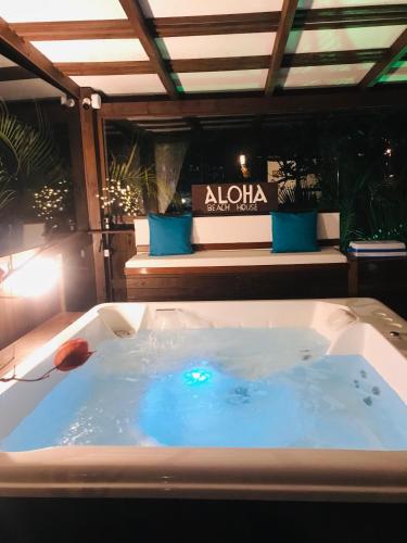a jacuzzi tub in a room with a couch at Pousada Aloha Beach House in Praia do Rosa
