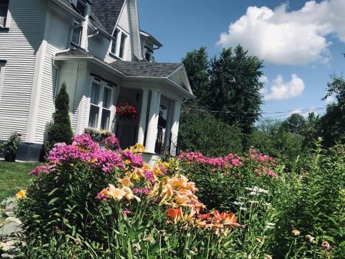 una casa con un ramo de flores en el patio en B&B Hillhouse, en Lac-Brome