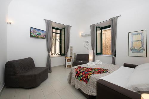 a bedroom with a bed and a chair and window at Amalfi 90 - holiday house close the beach in Atrani