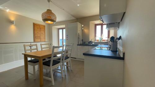 a kitchen with a wooden table and chairs and a counter at SeaHouse Apartments in Piran
