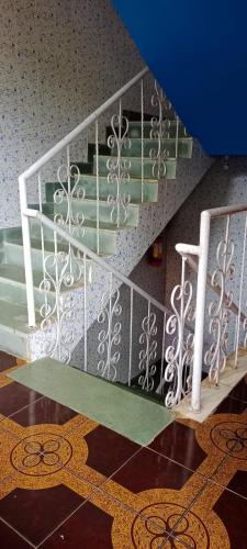 a room with a staircase with green and white at selfia guest house majorda in Majorda