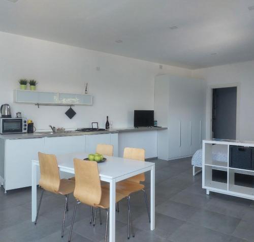 a white kitchen with a white table and chairs at Adagio Ravello in Ravello