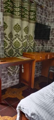 a room with a desk and a tv in a room at selfia guest house majorda in Majorda
