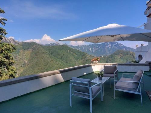 a patio with a table and chairs and an umbrella at Adagio Ravello in Ravello