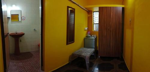 a yellow bathroom with a toilet and a sink at selfia guest house majorda in Majorda