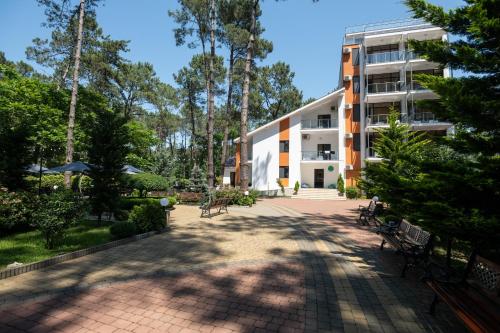 un bâtiment avec bancs et arbres devant lui dans l'établissement Buxus Hotel Shekvetili, à Shekvetili