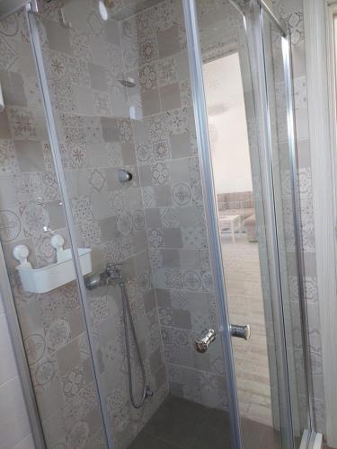 una ducha con puerta de cristal en un baño en Apartmani.Sutomore, en Sutomore