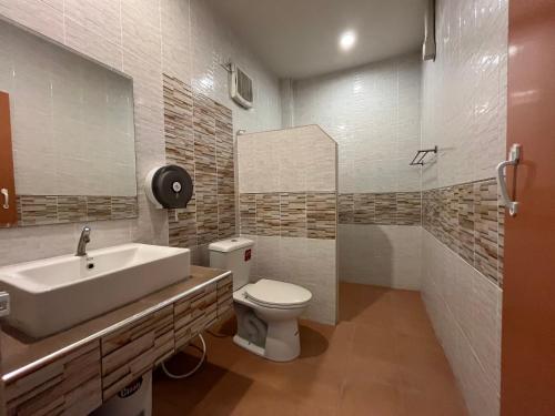 uma casa de banho com um lavatório branco e um WC. em The Palm Resort Kampeang Saen em Nakhon Pathom