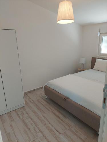 a white bedroom with a bed and a mirror at Apartmani.Sutomore in Sutomore