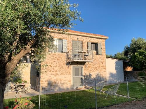 a brick house with a balcony in a yard at Messinian Stone House in Messini