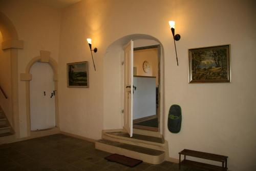 einen Flur mit Spiegel und Treppe in einem Gebäude in der Unterkunft Pfarrhaus Maxen in Müglitztal