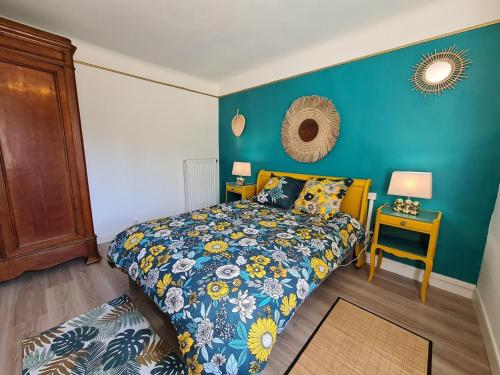 a bedroom with a bed with a blue wall at L'EssenCiel du Lac in Éguzon-Chantôme