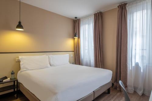 Кровать или кровати в номере Hotel Lilas Blanc