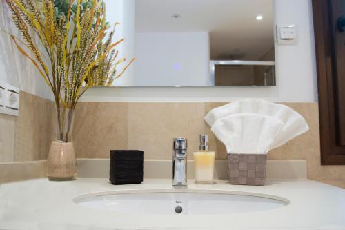 a bathroom sink with a soap dispenser and a candle at Edificio Ramiro in Marbella