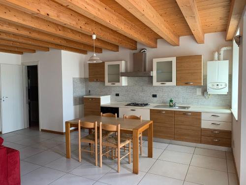 uma cozinha com uma mesa de madeira e um tecto de madeira em LA CASA DI MARTINA em Castelnuovo del Garda