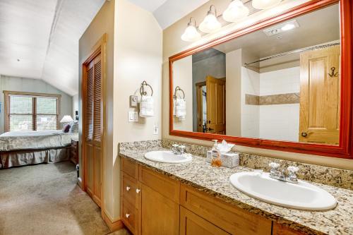 La salle de bains est pourvue de 2 lavabos et d'un grand miroir. dans l'établissement Copper Springs, à Copper Mountain