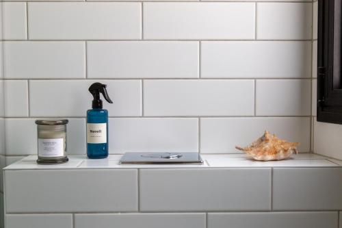 a bathroom counter with a bottle of soap and a laptop at The Alexander Apartment in Tel Aviv