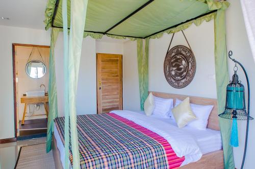 ein Schlafzimmer mit einem Himmelbett in der Unterkunft Nakorn De Sukhothai Hip Hotel in Sukhothai