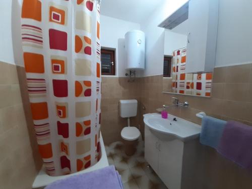 y baño con lavabo, aseo y cortina de ducha. en Apartments Cebalo - Ekonomija, en Korčula