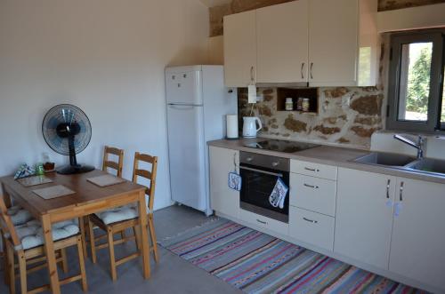 a kitchen with a table and a white refrigerator at Messinian Stone House in Messini