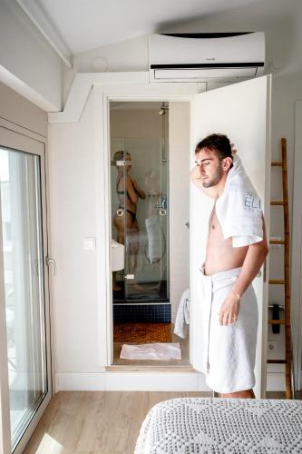 a man in a towel standing in a bathroom at Akti Elia Villas Beachfront Chalkidiki in Elia