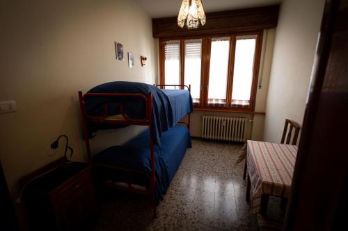 a living room with a blue chair and a window at Alloggio nel centro storico in Frabosa Soprana