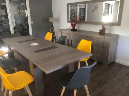 comedor con mesa de madera y sillas amarillas en MAISON FAMILLE, en Saint-Gervais