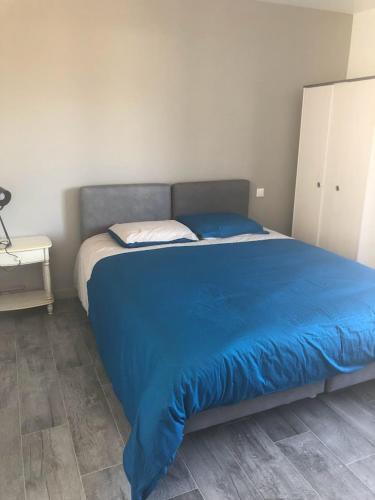 1 cama en un dormitorio con manta azul en MAISON FAMILLE, en Saint-Gervais