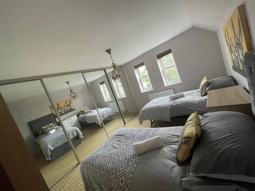 sypialnia z 2 łóżkami i lustrem w obiekcie Entire seaside Luxury home with on site parking! w Poole