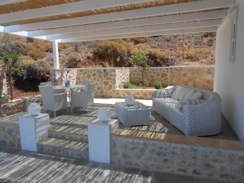 un patio con sofá y una mesa en una terraza en HydraVista (Lily) en Hydra