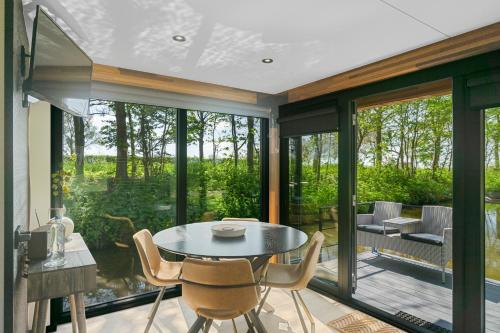 a dining room with a table and chairs at Waterlodges WeidumerHout in Weidum