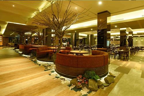 a lobby with a restaurant with tables and chairs at Holiday Inn Cikarang Jababeka by IHG in Cikarang